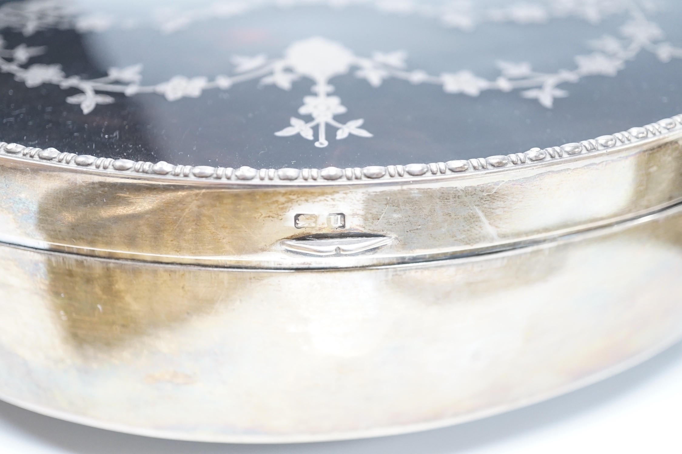 A George V silver and tortoiseshell piqué mounted trinket box, Levi & Salaman, Birmingham, 1918, 19cm and a matched three piece silver and tortoiseshell mounted mirror and brush set.